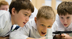 Three boys doing experiments in laboratory