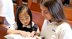 Couple of girls reading bible at church